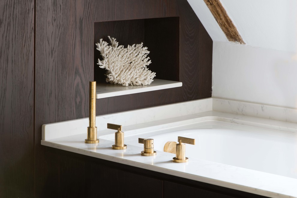 Inspiration for a small contemporary bathroom in Sussex with flat-panel cabinets, brown cabinets, a corner tub, a wall-mount toilet, white walls, black floor and white benchtops.
