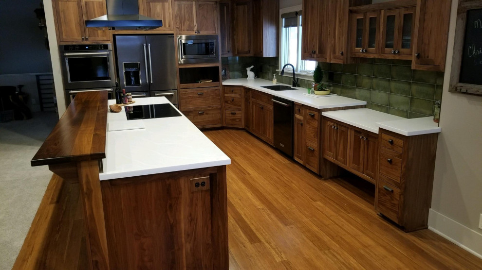 Galley eat-in kitchen photo with an undermount sink and solid surface countertops
