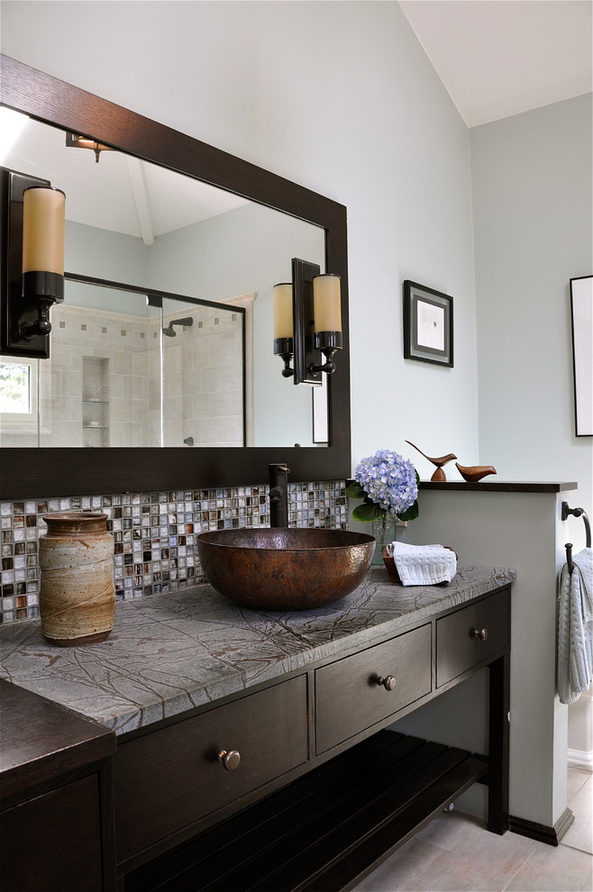 Photo of a mid-sized contemporary master bathroom in New York with mosaic tile, soapstone benchtops, a vessel sink, flat-panel cabinets, brown cabinets, an alcove shower, a one-piece toilet, gray tile, blue walls, porcelain floors, grey floor, a hinged shower door and grey benchtops.