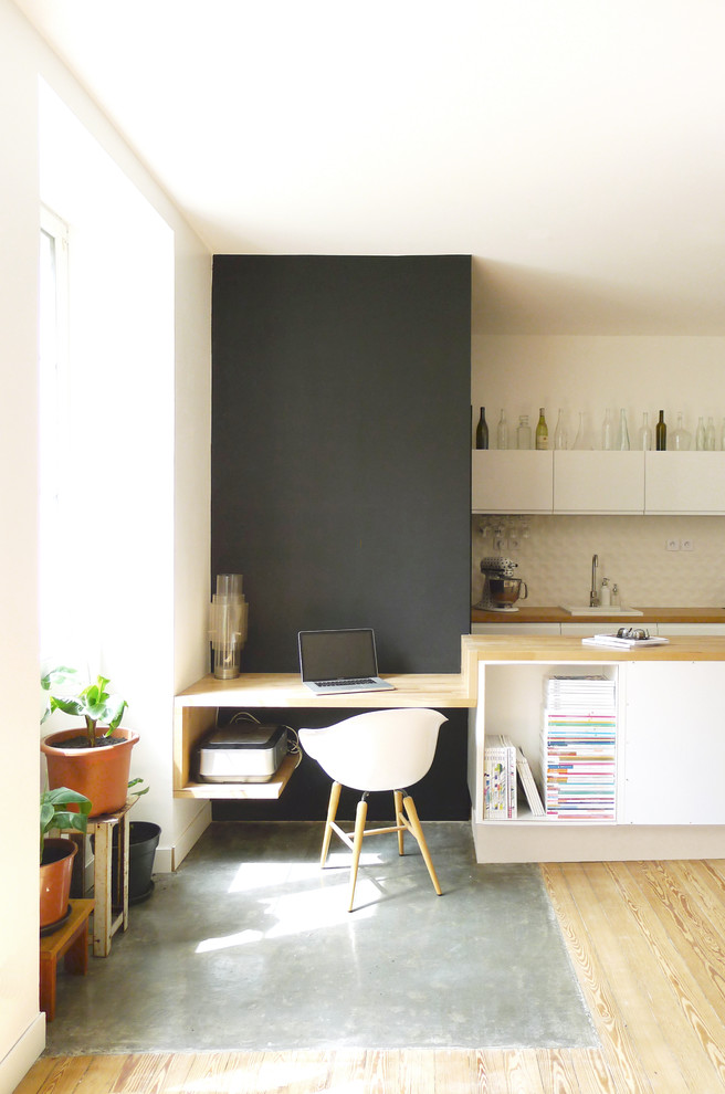 This is an example of a small contemporary study room in Nantes with a built-in desk and light hardwood floors.