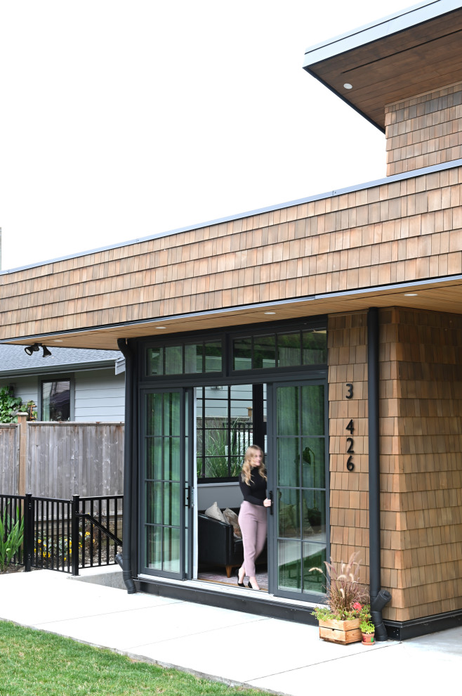 This is an example of a small and brown contemporary two floor tiny house in Vancouver with wood cladding, a lean-to roof, a shingle roof, a black roof and shingles.