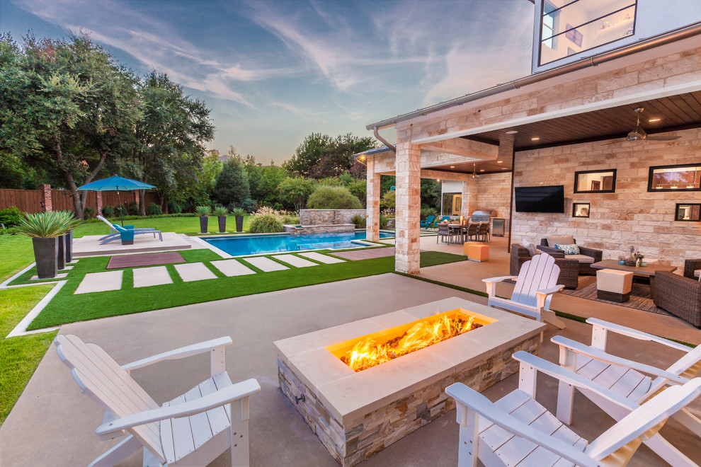 This is an example of a contemporary backyard patio in Dallas with a fire feature, concrete slab and a roof extension.