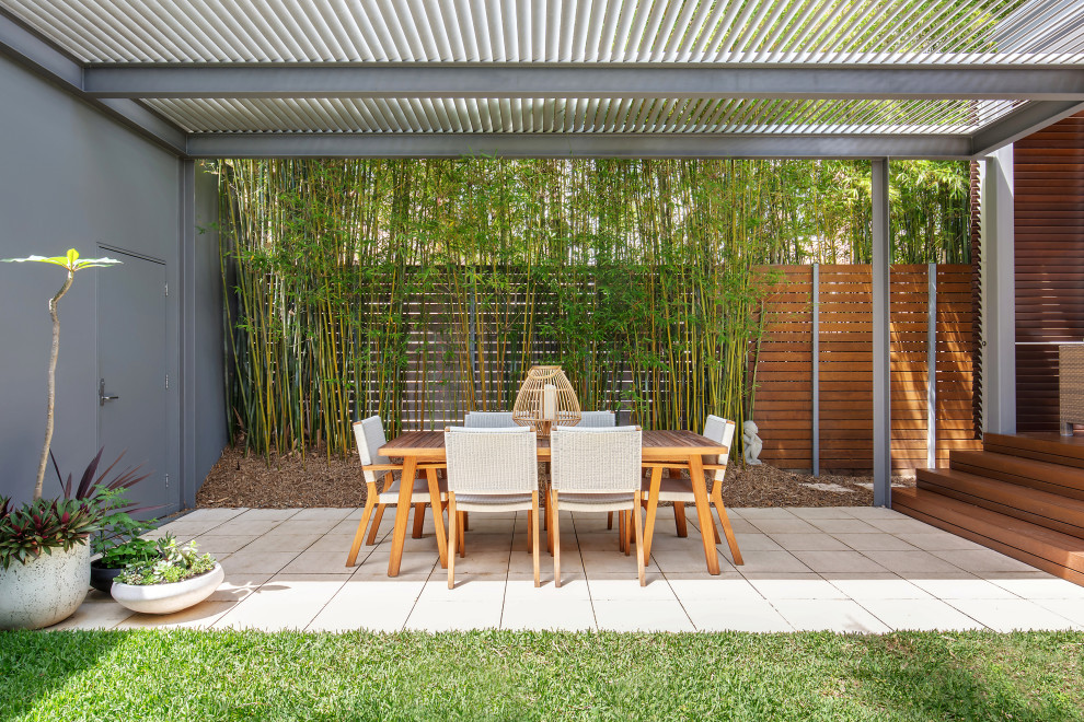 Inspiration for a mid-sized beach style backyard patio in Sydney with concrete pavers and a pergola.
