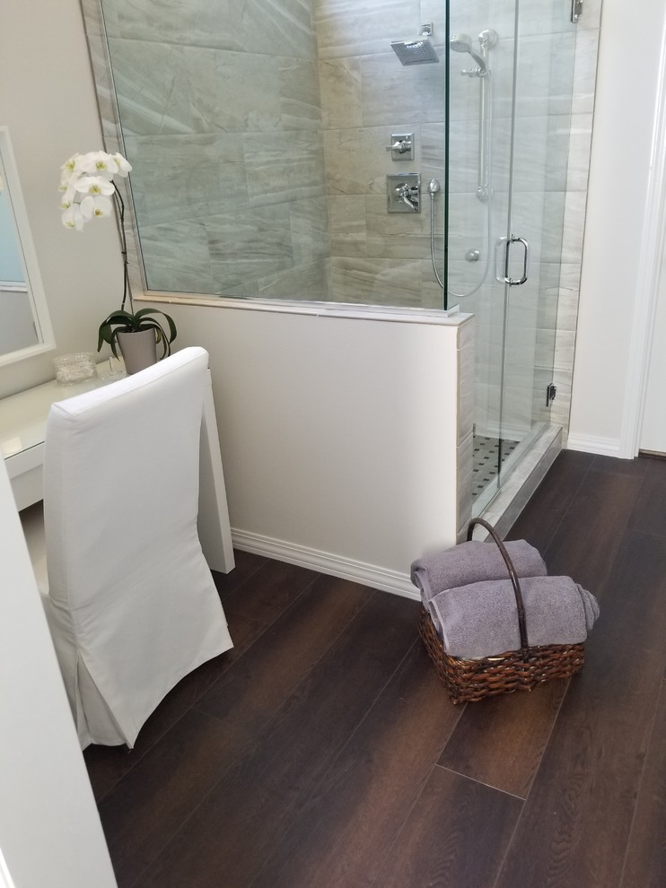 This is an example of a mid-sized modern master bathroom in Portland with an alcove shower, gray tile, porcelain tile, beige walls, vinyl floors, brown floor and a hinged shower door.
