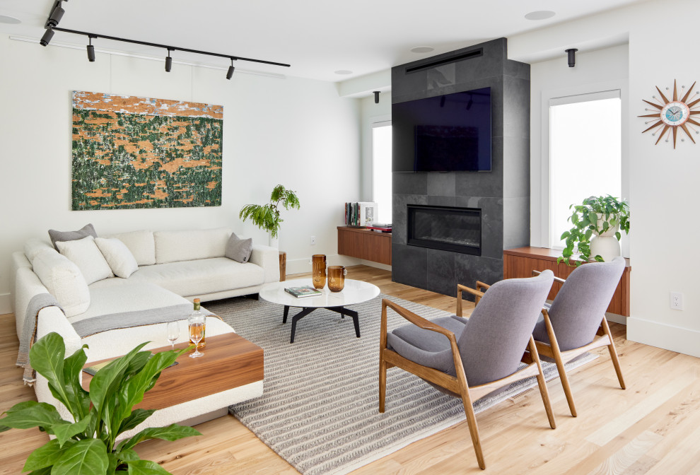 Mid-sized contemporary open concept living room in Toronto with white walls, light hardwood floors, a stone fireplace surround and a wall-mounted tv.