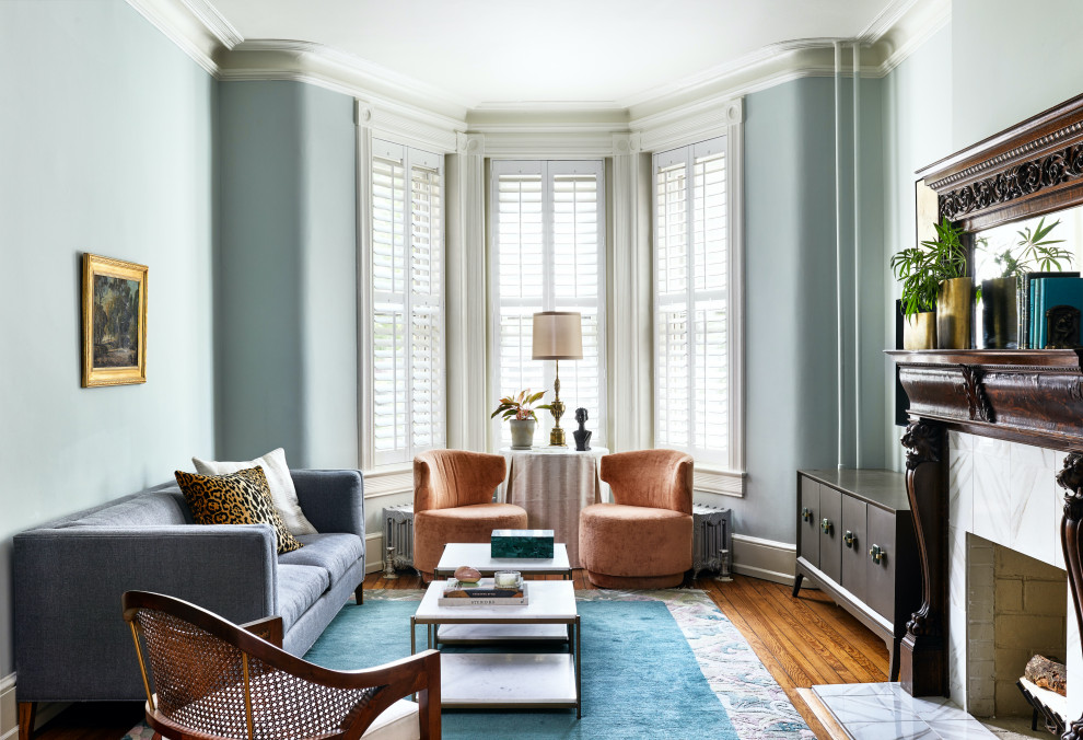 Inspiration for a mid-sized transitional medium tone wood floor and brown floor living room remodel in Philadelphia with green walls, a wood fireplace surround and a wall-mounted tv