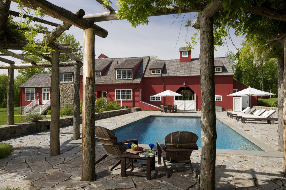 Expansive country side yard rectangular pool in New York with natural stone pavers.