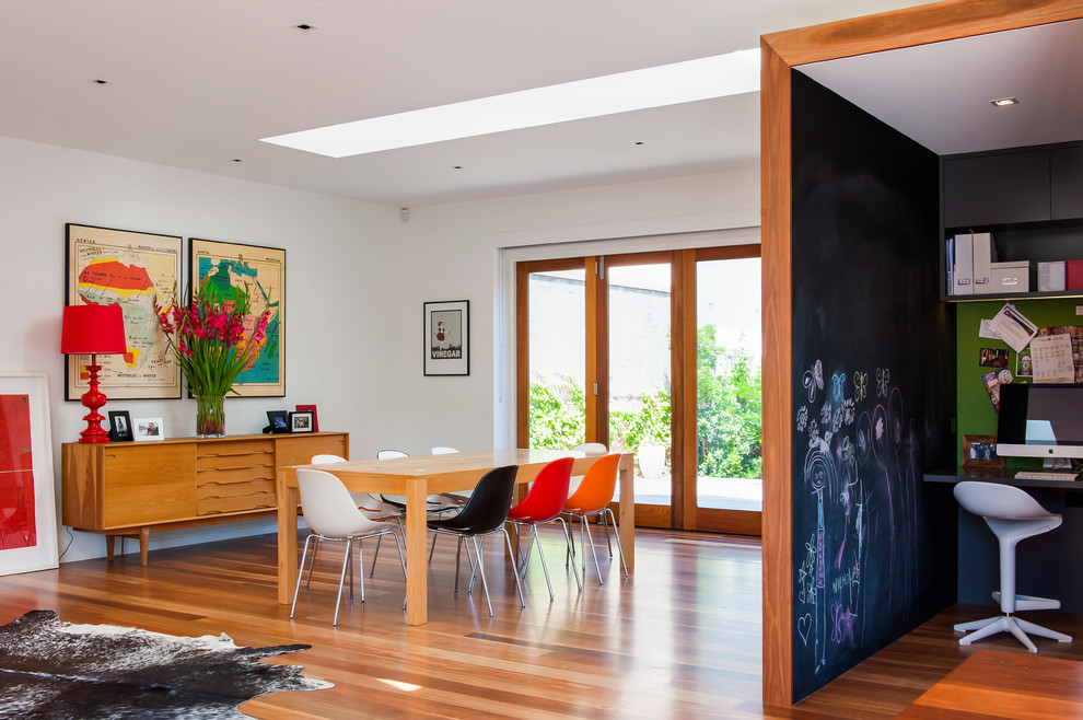This is an example of a contemporary open plan dining in Melbourne with medium hardwood floors.