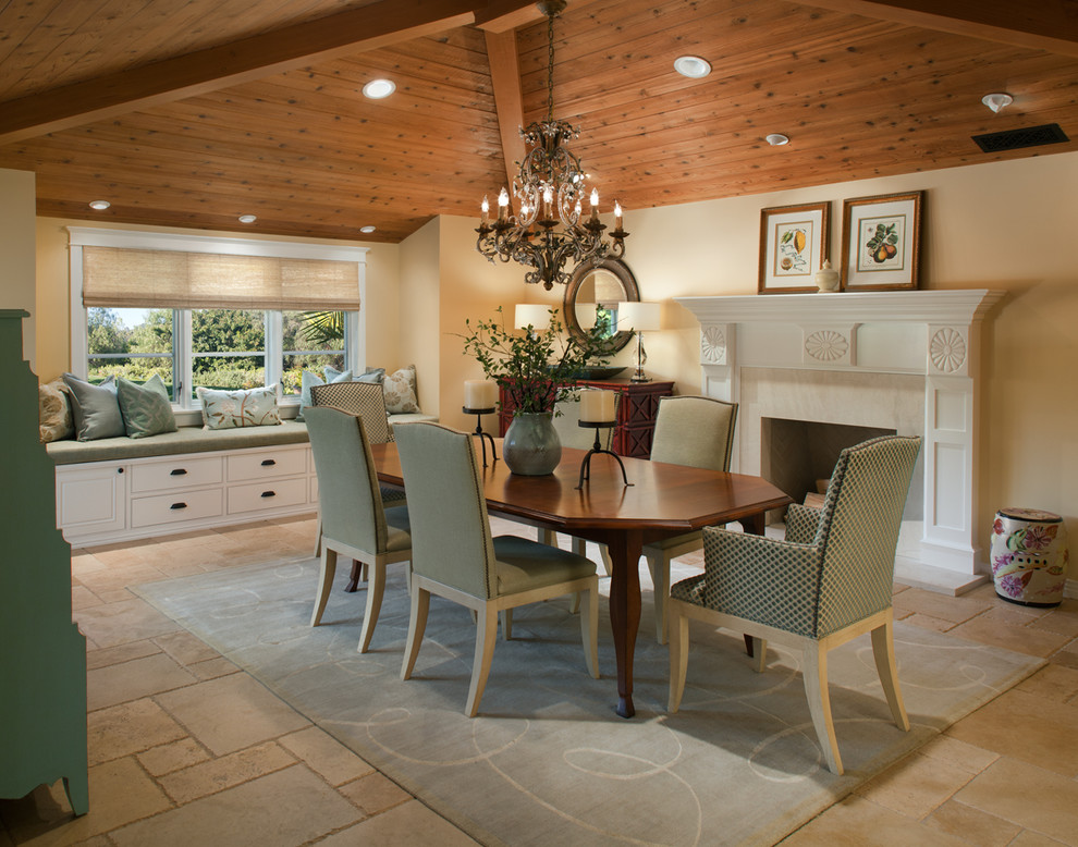 Inspiration for a mid-sized traditional separate dining room in San Diego with beige walls, travertine floors and a standard fireplace.