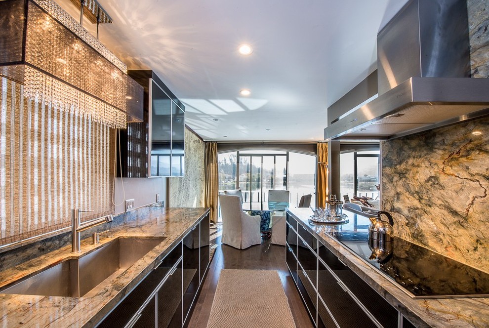 Photo of a large contemporary galley open plan kitchen in San Francisco with an undermount sink, flat-panel cabinets, black cabinets, granite benchtops, multi-coloured splashback, stone slab splashback, stainless steel appliances, dark hardwood floors, no island and brown floor.