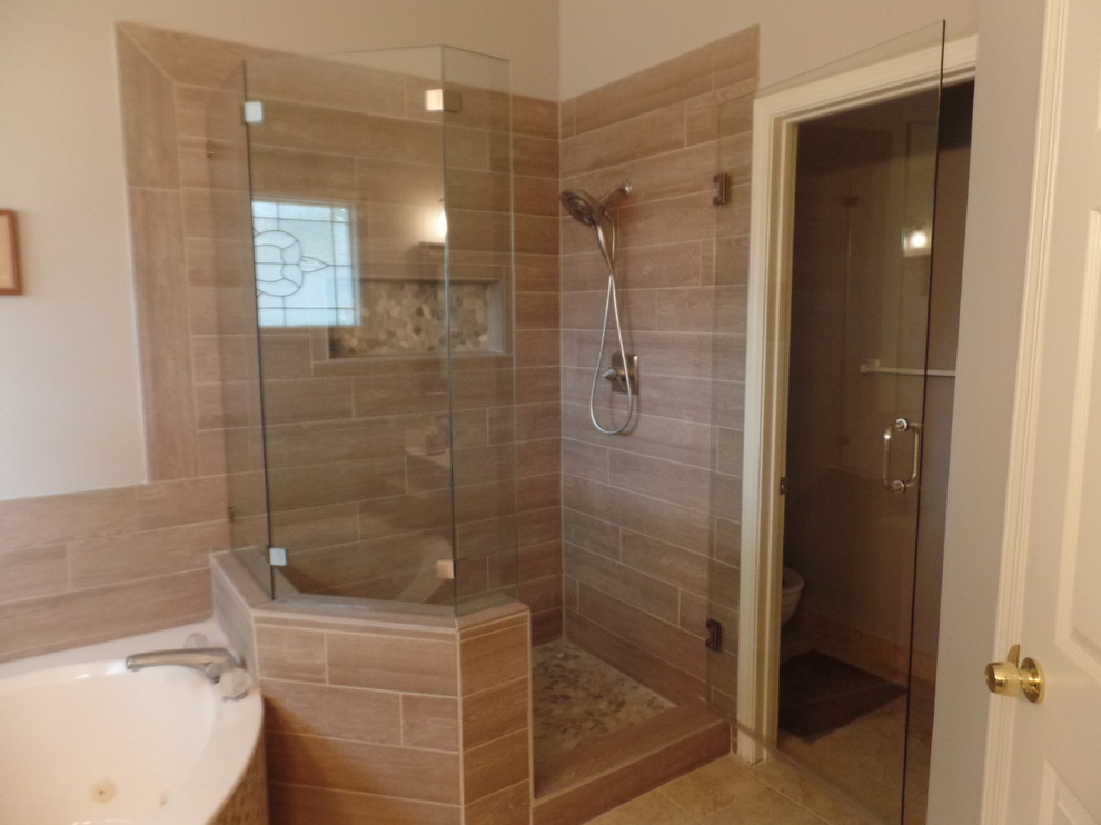 Corner shower - mid-sized transitional master brown tile and porcelain tile corner shower idea with beige walls and a hinged shower door