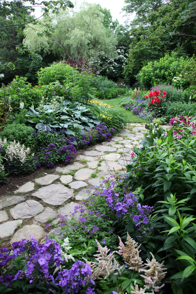 Photo of a large traditional partial sun backyard brick landscaping in New York.