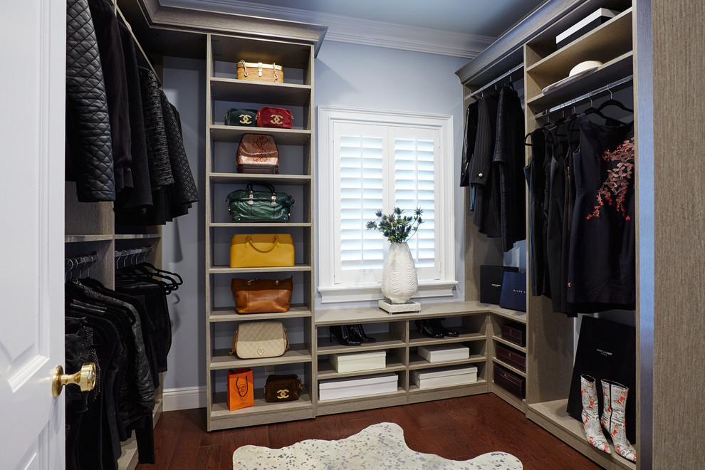 Design ideas for a mid-sized transitional women's walk-in wardrobe in New York with open cabinets, grey cabinets and medium hardwood floors.