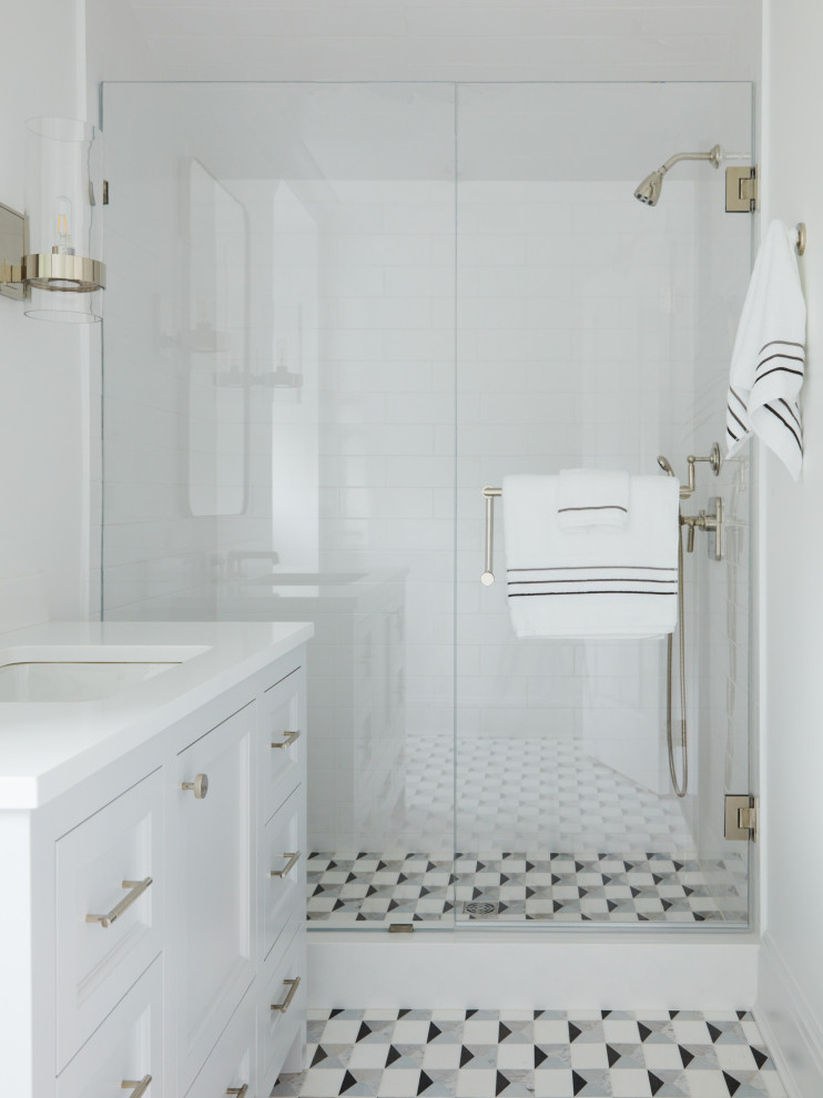 Small transitional 3/4 multicolored tile mosaic tile floor, multicolored floor and single-sink corner shower photo in New York with recessed-panel cabinets, a two-piece toilet, multicolored walls, an undermount sink, a hinged shower door, white countertops, a freestanding vanity and gray cabinets