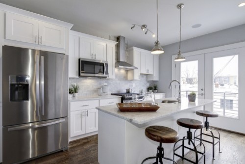 Example of a small transitional galley dark wood floor eat-in kitchen design in DC Metro with an undermount sink, shaker cabinets, white cabinets, marble countertops, gray backsplash, stainless steel appliances and an island