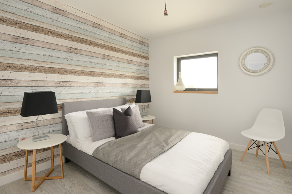 This is an example of a transitional bedroom in Kent with multi-coloured walls, light hardwood floors and grey floor.