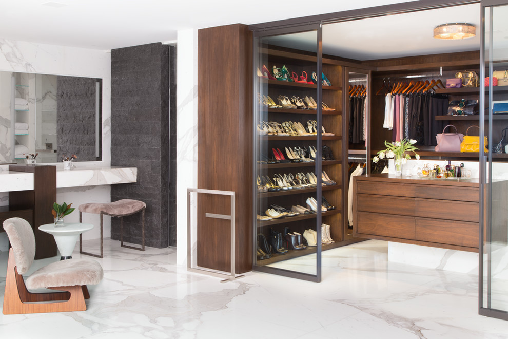 Contemporary women's walk-in wardrobe in Los Angeles with flat-panel cabinets, dark wood cabinets, marble floors and white floor.