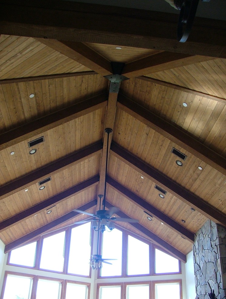 Example of a large mountain style loft-style medium tone wood floor home design design in Phoenix with a bar, beige walls, a rumford fireplace, a stone fireplace and a wall-mounted tv