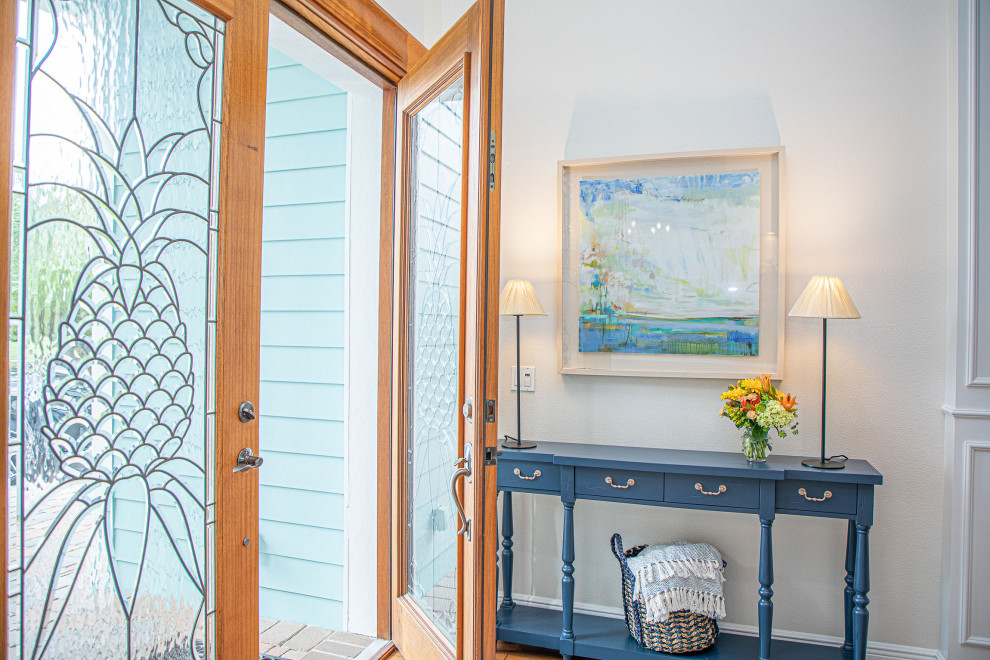 Стильный дизайн: большая входная дверь в морском стиле с белыми стенами, паркетным полом среднего тона, одностворчатой входной дверью и входной дверью из дерева среднего тона - последний тренд