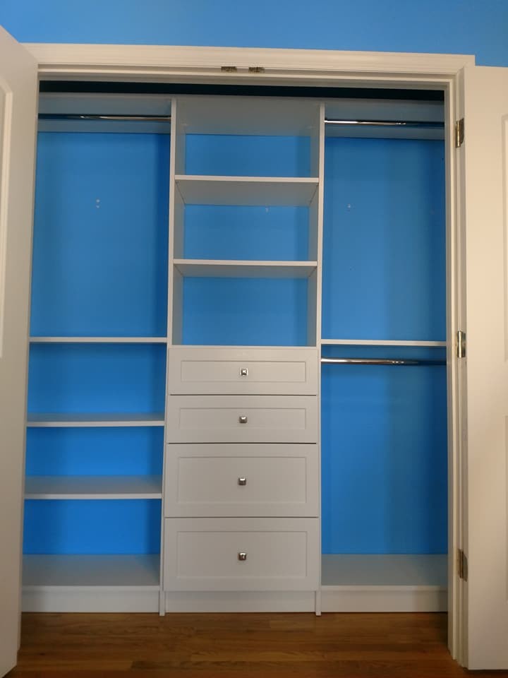 Mid-sized modern gender-neutral built-in wardrobe in New York with shaker cabinets, white cabinets and medium hardwood floors.
