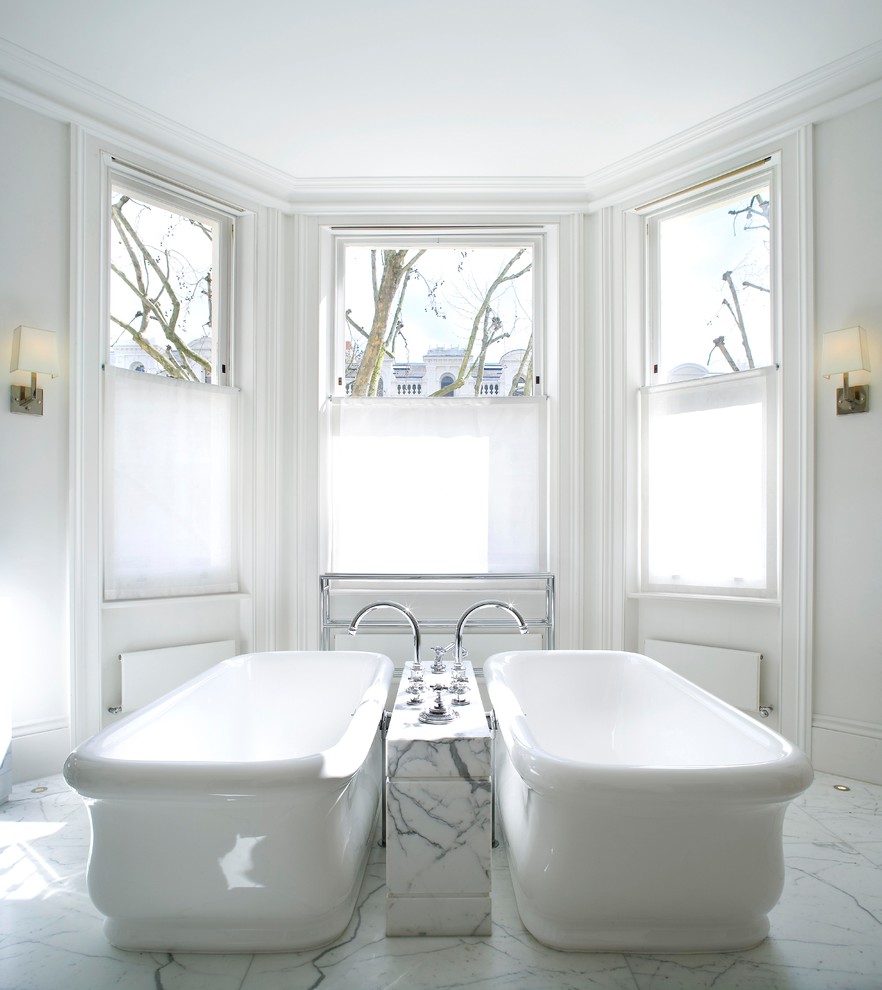Design ideas for a large contemporary master bathroom in London with furniture-like cabinets, white cabinets, a freestanding tub, a curbless shower, a two-piece toilet, white tile, marble, white walls, marble floors, a console sink and marble benchtops.