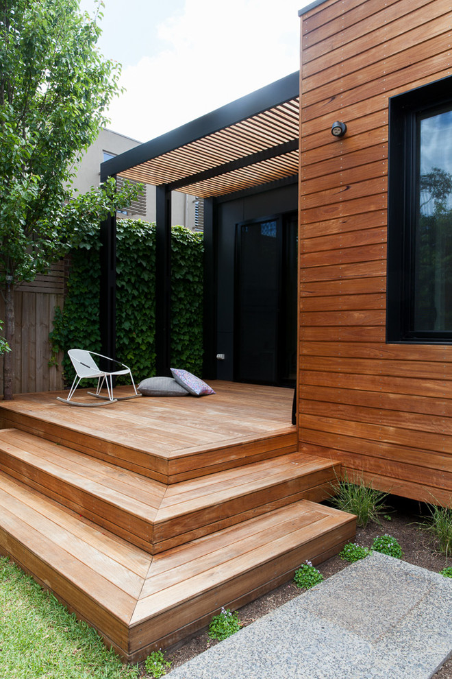 Design ideas for a contemporary one-storey brown exterior in Melbourne with wood siding and a flat roof.