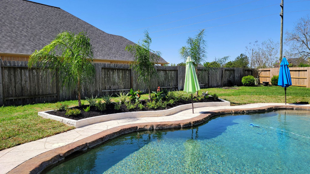 Cette image montre un jardin arrière traditionnel de taille moyenne et l'été avec une exposition ensoleillée et des pavés en pierre naturelle.