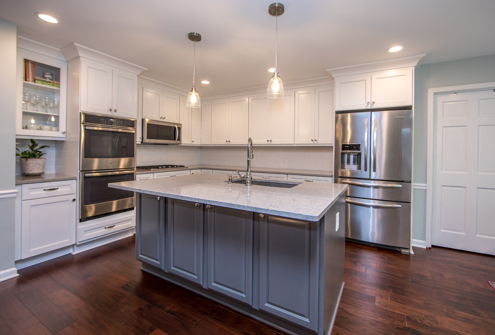 Eat-in kitchen - mid-sized transitional l-shaped brown floor eat-in kitchen idea in Atlanta with an undermount sink, white cabinets, quartzite countertops, white backsplash, subway tile backsplash, stainless steel appliances, an island and gray countertops