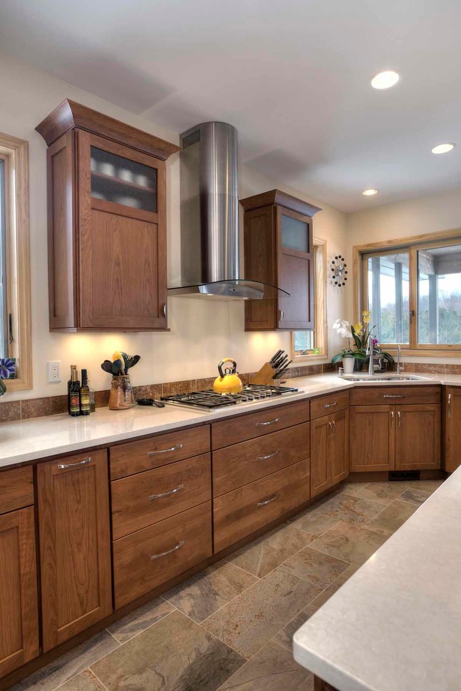 Example of a mid-sized transitional u-shaped slate floor eat-in kitchen design with an undermount sink, flat-panel cabinets, medium tone wood cabinets, quartz countertops, brown backsplash, stone tile backsplash, stainless steel appliances and an island