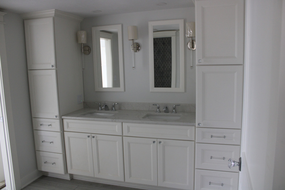 Klassisk inredning av ett litet grå grått en-suite badrum, med släta luckor, vita skåp, blå väggar, laminatgolv, ett undermonterad handfat, bänkskiva i kvarts och grått golv