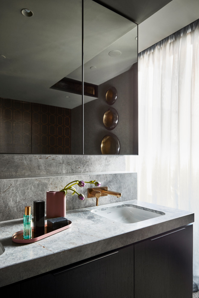 This is an example of a mid-sized contemporary master bathroom in Melbourne with furniture-like cabinets, black cabinets, a freestanding tub, a double shower, a one-piece toilet, black tile, ceramic tile, black walls, ceramic floors, an undermount sink, marble benchtops, brown floor, an open shower, grey benchtops, an enclosed toilet, a double vanity, a built-in vanity and wallpaper.