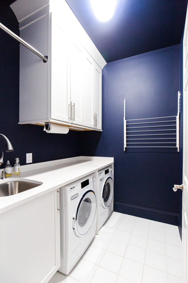 Foto de cuarto de lavado lineal ecléctico pequeño con fregadero de un seno, armarios estilo shaker, puertas de armario blancas, encimera de cuarzo compacto, paredes azules, lavadora y secadora juntas y encimeras blancas