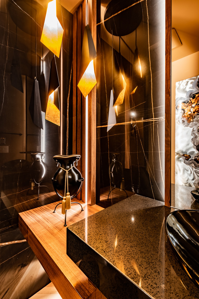 Mittelgroße Moderne Gästetoilette mit schwarzen Schränken, Toilette mit Aufsatzspülkasten, schwarzen Fliesen, Porzellanfliesen, schwarzer Wandfarbe, hellem Holzboden, Aufsatzwaschbecken, Granit-Waschbecken/Waschtisch, schwarzer Waschtischplatte, schwebendem Waschtisch und Wandpaneelen in Calgary