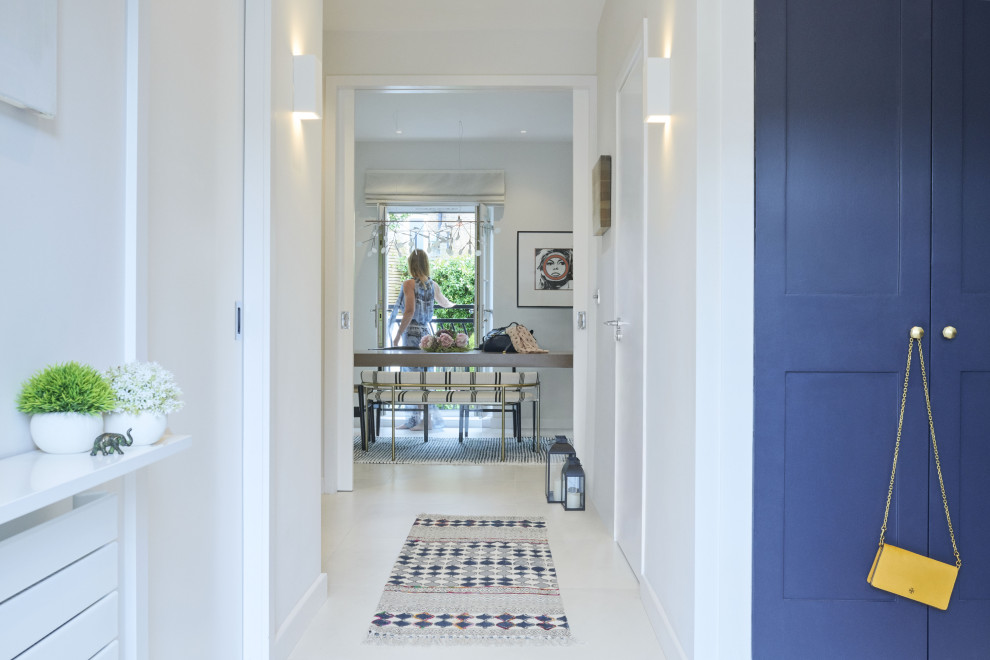 Ispirazione per un ingresso o corridoio minimal di medie dimensioni con pareti bianche, pavimento in gres porcellanato e pavimento bianco