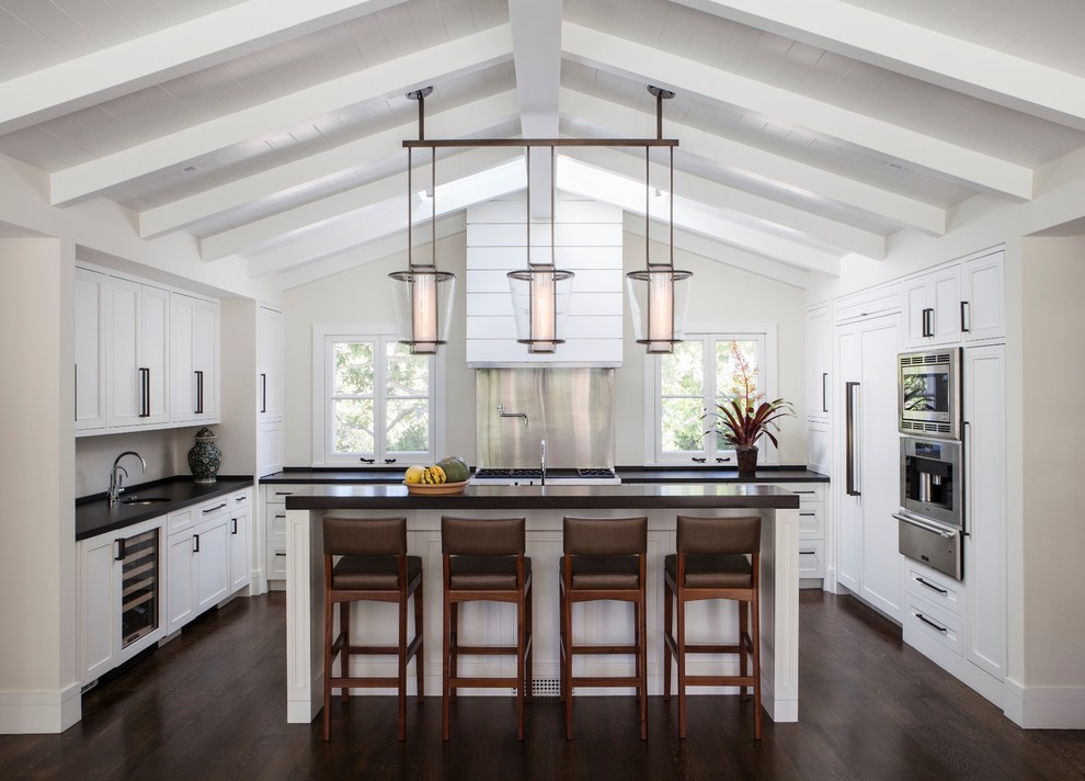 This is an example of a transitional u-shaped kitchen in San Francisco with shaker cabinets, white cabinets, stainless steel appliances, dark hardwood floors and with island.