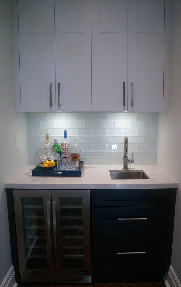 Transitional galley dark wood floor kitchen photo in Toronto with an undermount sink, shaker cabinets, white cabinets, quartz countertops, blue backsplash, glass tile backsplash, stainless steel appliances and an island