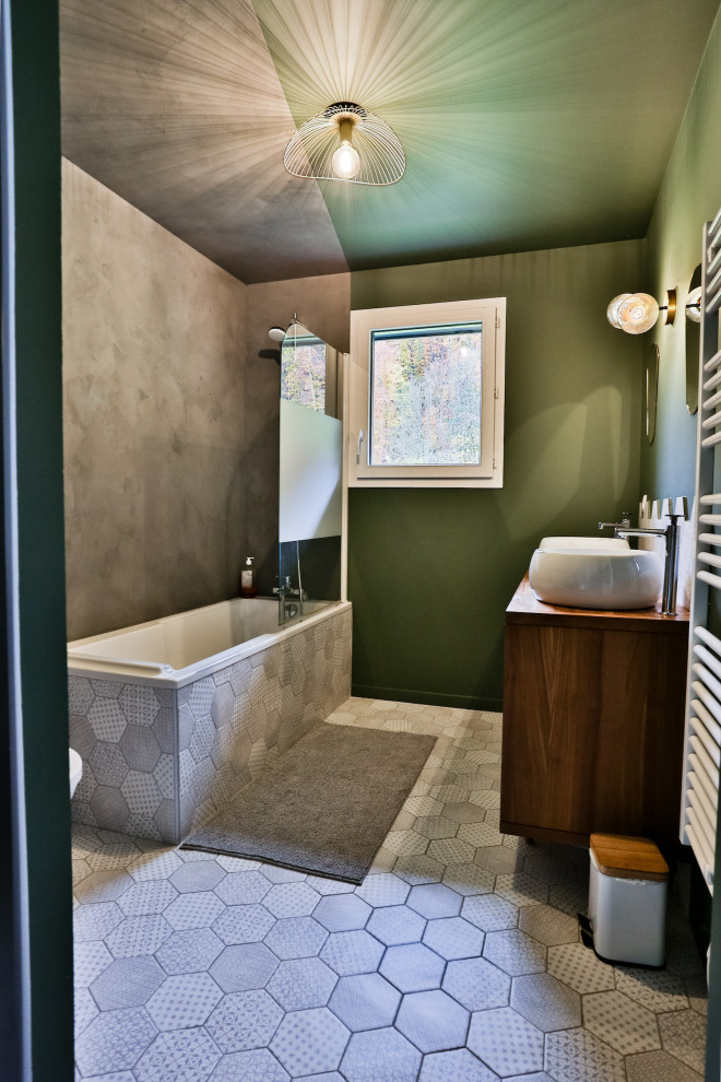 Aménagement d'une grande salle de bain principale éclectique avec une baignoire encastrée, WC suspendus, un carrelage gris, des carreaux en terre cuite, un mur vert, tomettes au sol, un lavabo posé, un sol gris et meuble double vasque.