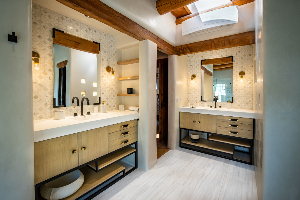Modernes Badezimmer mit flächenbündigen Schrankfronten, hellen Holzschränken, grauen Fliesen, Unterbauwaschbecken, weißem Boden, weißer Waschtischplatte, Doppelwaschbecken, freistehendem Waschtisch und freigelegten Dachbalken in Albuquerque