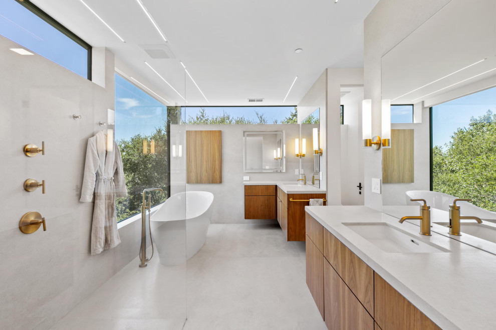 Design ideas for a large modern master bathroom in San Francisco with flat-panel cabinets, brown cabinets, a freestanding tub, an open shower, a one-piece toilet, beige tile, limestone, white walls, limestone floors, an undermount sink, limestone benchtops, beige floor, an open shower, beige benchtops, an enclosed toilet, a double vanity and a floating vanity.