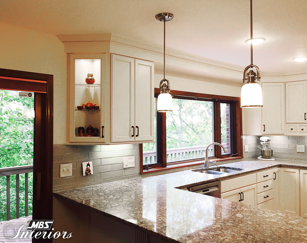 Transitional u-shaped enclosed kitchen photo with an undermount sink, flat-panel cabinets, white cabinets, quartz countertops, gray backsplash, subway tile backsplash, stainless steel appliances and a peninsula