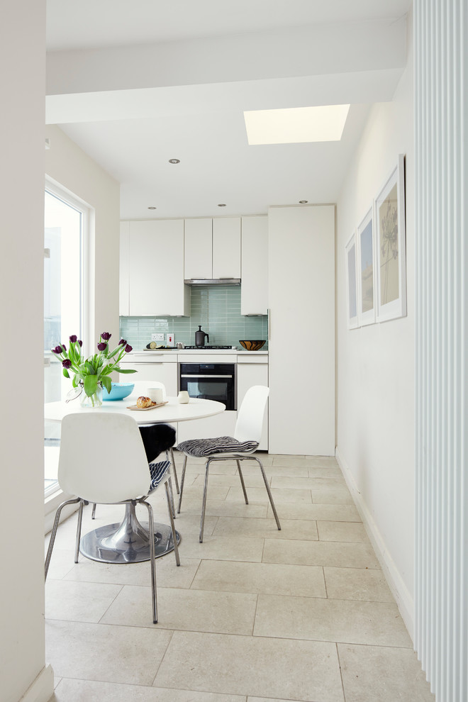 This is an example of a small scandinavian kitchen/dining combo in Dublin with white walls, porcelain floors, no fireplace and white floor.