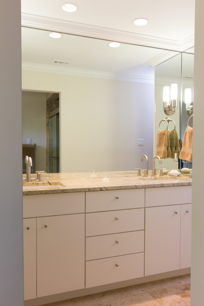 Mid-sized contemporary bathroom in Austin with white cabinets, white walls, porcelain floors, an undermount sink, multi-coloured tile, mirror tile, granite benchtops, beige floor and white benchtops.