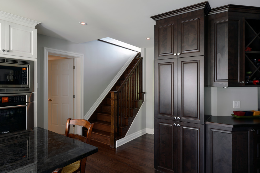 Mid-sized transitional l-shaped dark wood floor eat-in kitchen photo in Ottawa with a single-bowl sink, raised-panel cabinets, white cabinets, granite countertops, gray backsplash, ceramic backsplash, stainless steel appliances and an island