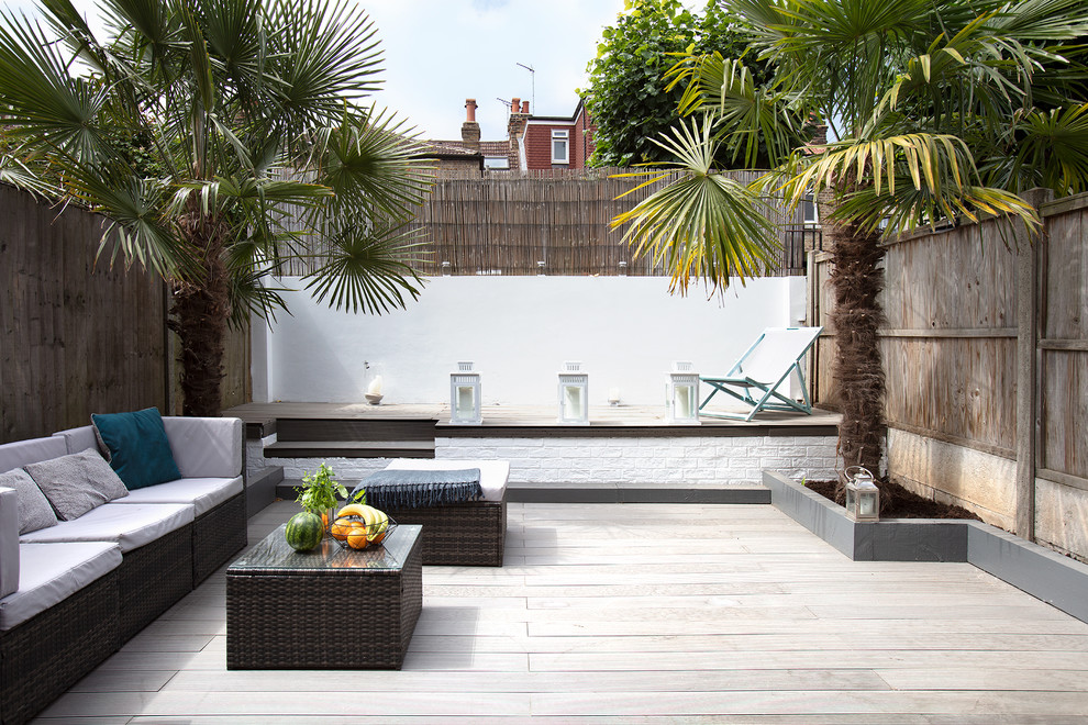 This is an example of a mid-sized contemporary backyard deck in London with a container garden.
