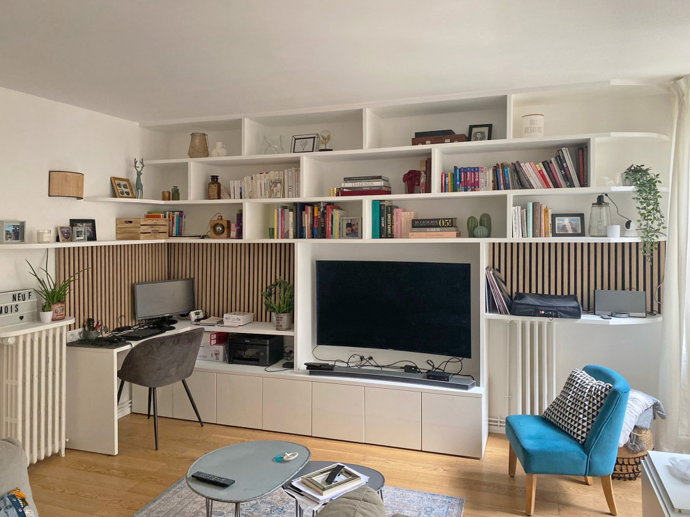 Immagine di un grande soggiorno nordico aperto con libreria, pareti bianche, parquet chiaro e TV autoportante