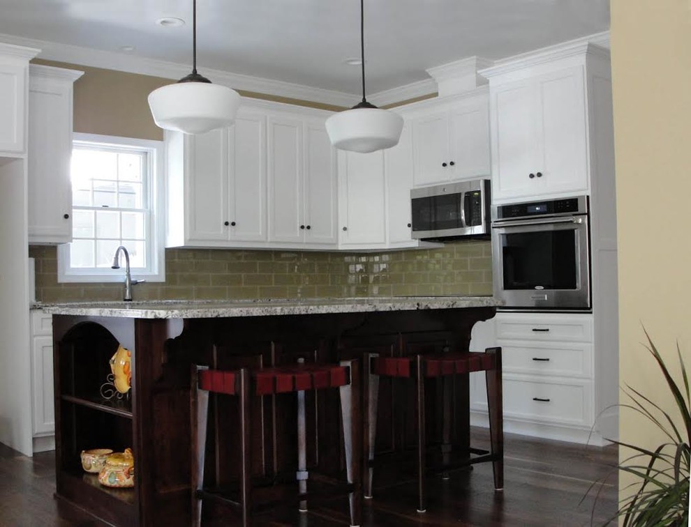 This is an example of a large traditional l-shaped open plan kitchen in DC Metro with an undermount sink, recessed-panel cabinets, white cabinets, granite benchtops, beige splashback, glass tile splashback, stainless steel appliances, dark hardwood floors and with island.