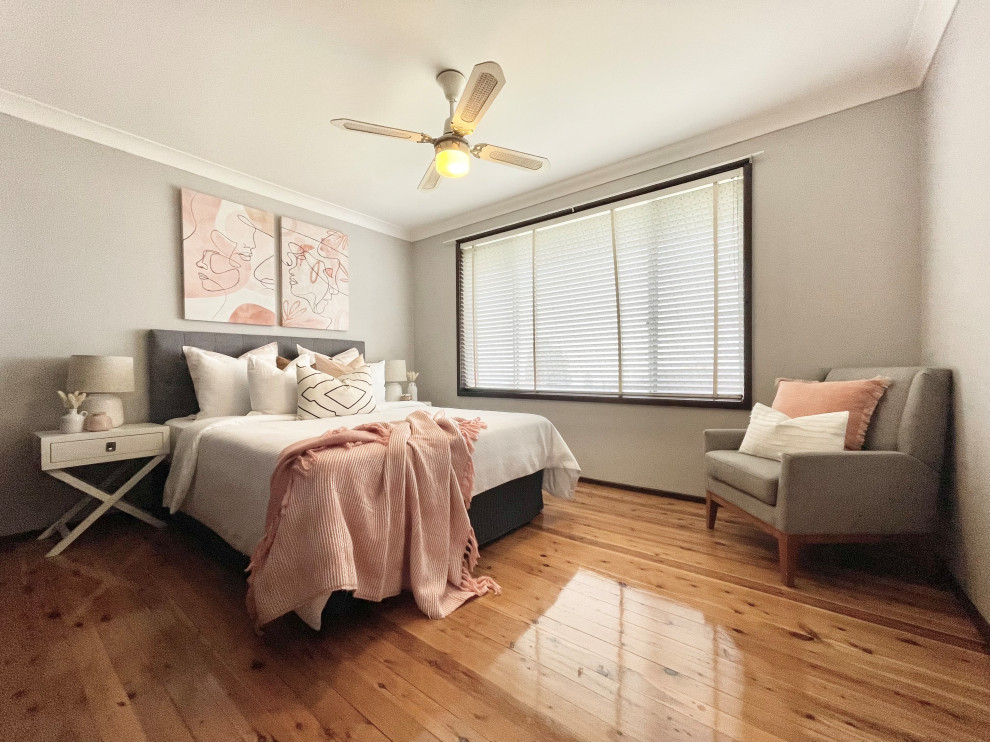 Mid-sized trendy master medium tone wood floor and multicolored floor bedroom photo in Sydney with beige walls