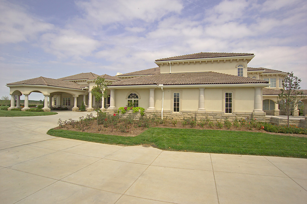 Design ideas for an expansive mediterranean two-storey stucco beige exterior in Omaha.