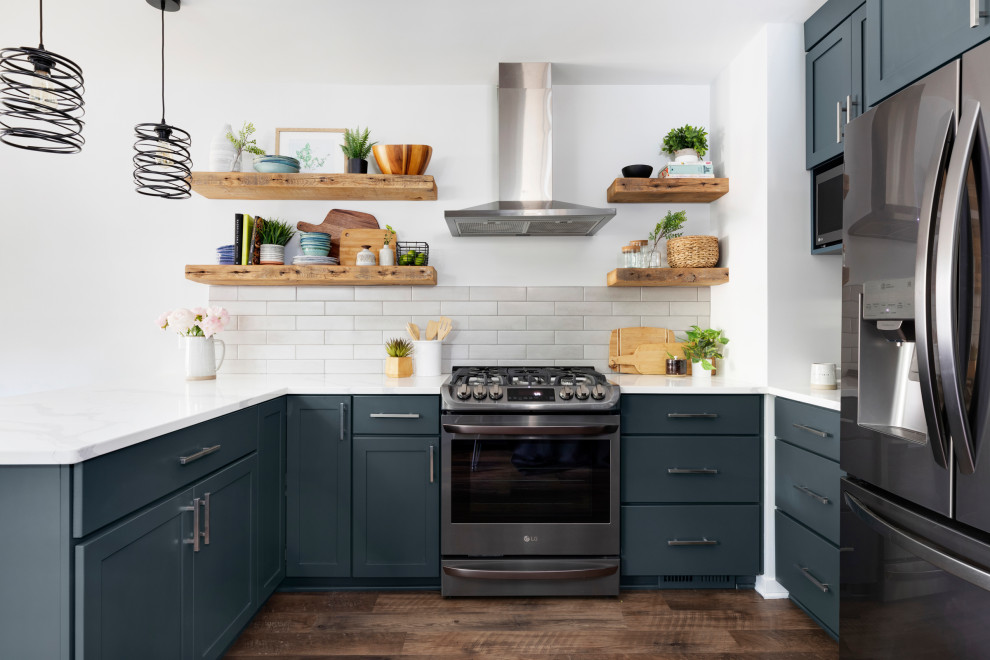 Inspiration for a mid-sized transitional u-shaped eat-in kitchen in Minneapolis with an undermount sink, shaker cabinets, blue cabinets, quartz benchtops, grey splashback, ceramic splashback, stainless steel appliances, vinyl floors, a peninsula, brown floor and white benchtop.