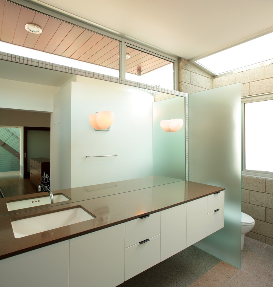 Photo of a modern bathroom in Los Angeles with an undermount sink, flat-panel cabinets and white cabinets.